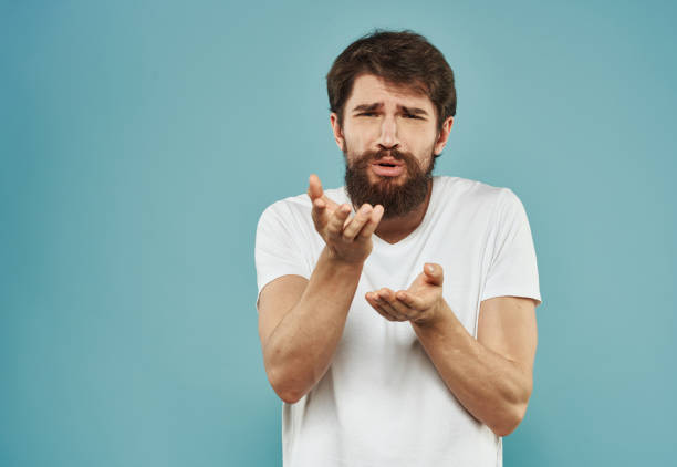 istock Young man with a beard on a blue background emotions model frightened look 2150957178