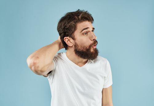Puzzled man with a beard on a blue background emotions of surprise. High quality photo