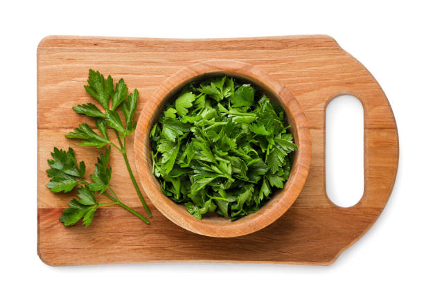 istock Chopped parsley and leaves on a kitchen board on a white background. Top view 2150959341