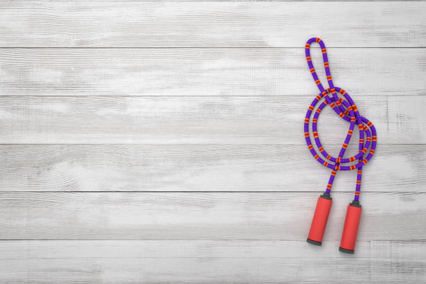 3d rendering of violet jumping rope on wooden background. Sports and fitness. Sporting goods. Fitness and workout.
