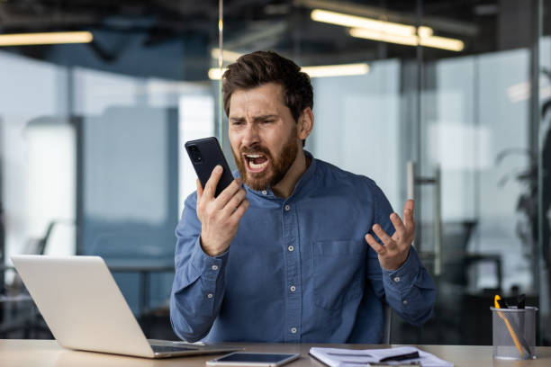 istock Frustrated businessman arguing on phone at office desk 2150965286