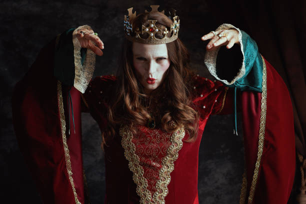 istock scary medieval queen in red dress with white makeup and crown 2150965949