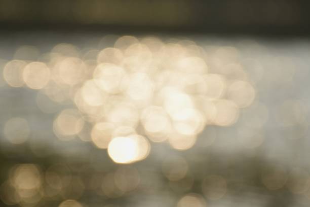 close up of blurry sea with reflection of sun on sunny day background and texture