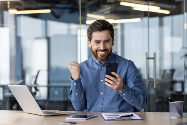 istock Successful businessman celebrating victory in office 2150969866
