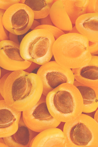 Ripe juicy orange apricots slices fruit background.