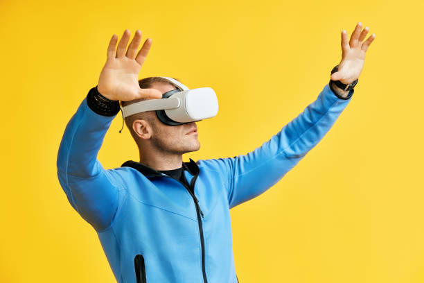 istock Man wearing virtual reality goggles over yellow background 2150971496