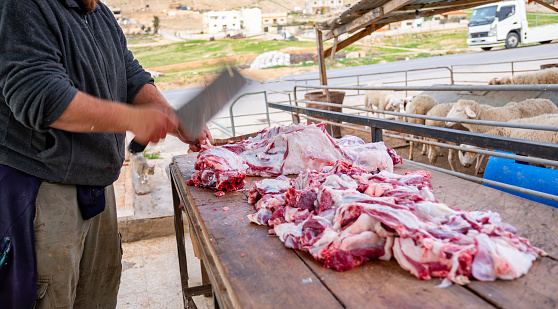 Muslim man butchers trimming a Sheep to be distributed to muslims in needs during Eid Al-Adha Al Mubarak
