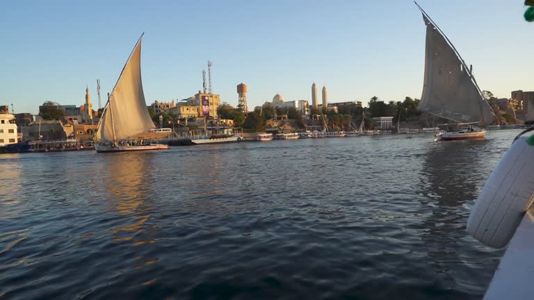Boats Sailing down Nile river in Aswan Egypt at sunset