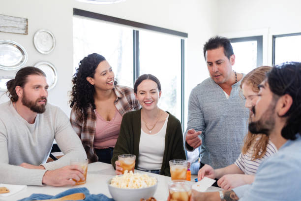 istock Friend group gathers around snacks on kitchen island 2150977491