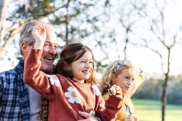 istock Grandfather smiles proudly while spending time with his granddaughters 2150980164
