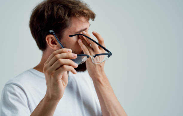 istock vision problems man holding glasses in hand pain in the eyes gray background 2150980804