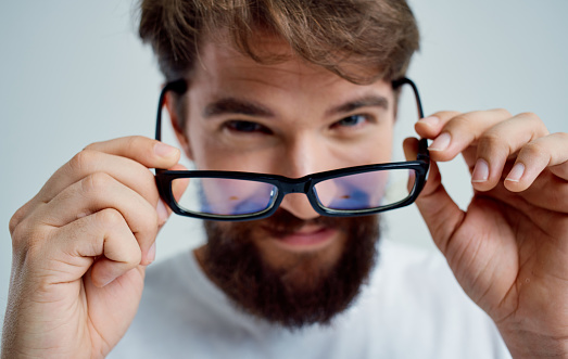 bearded man in white t-shirt with glasses vision problems. High quality photo