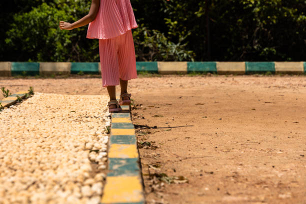 a little girl as she embarks on a whimsical adventure along a serene side pathway in the park.