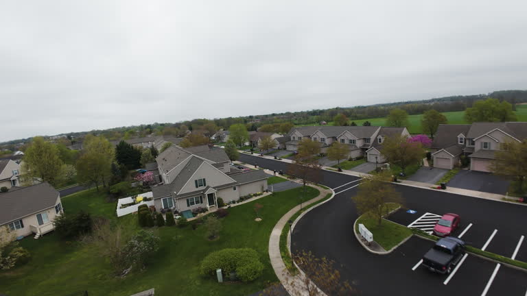 FPV flight over baseball field and housing area in american suburb. Cloudy day in USA. Residential area with noble buildings and homes.
