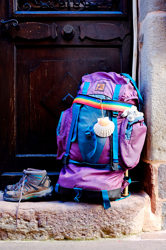 Pilgrim's backpack and shoes on the Way of Saint James (Camino de Santiago). The scallop shell is the symbol of the Camino de Santiago.