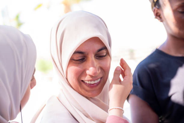 istock muslim female adjusting her hijab with a help  from other person 2150986569