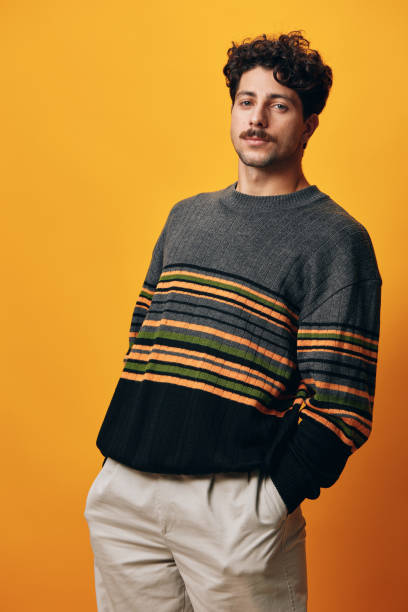 istock Student man trendy natural happy orange expression sweater handsome background smile modern fashion hand portrait 2150987118
