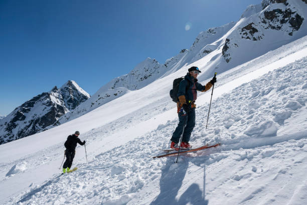 istock Backcountry skiers climb mountain 2150987825