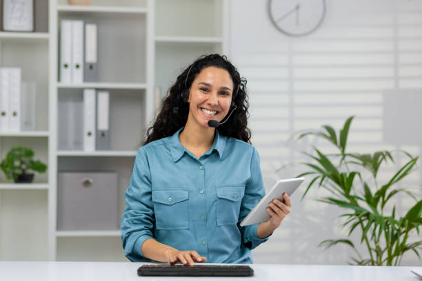 istock Smiling Hispanic woman making a video call at office desk 2150987838