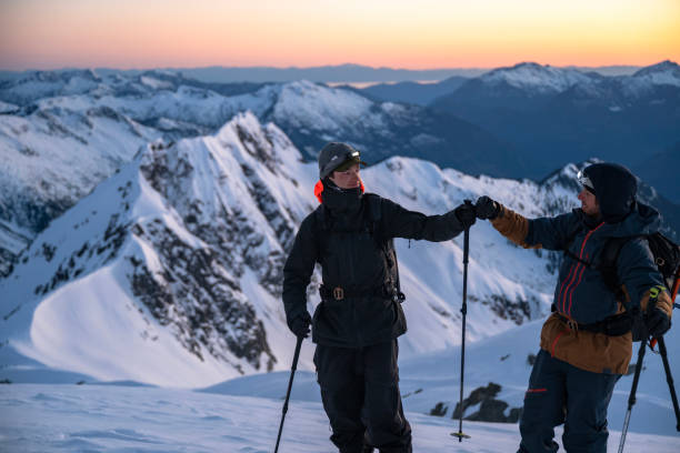 istock Two ski mountaineers pause on mountain at twilight 2150987854