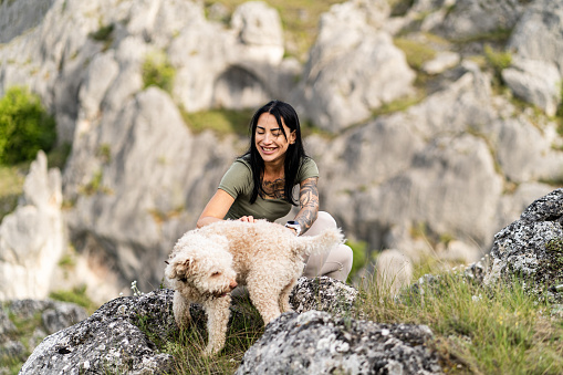 A woman is hiking during the morning with her cute dog