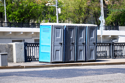 A line of portable plastic toilets on the sidewalk