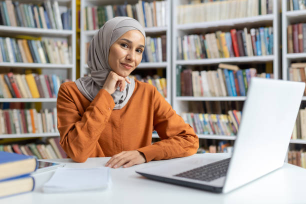 istock Confident Muslim woman using laptop in library setting 2150998557