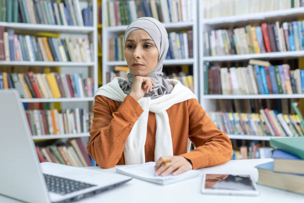 istock Focused Muslim woman studying in library with laptop 2150998934