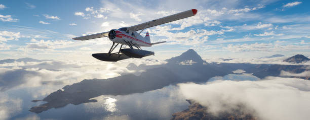 istock Airplane flying over mountains, lakes, and clouds. Sunny Da 2150999864