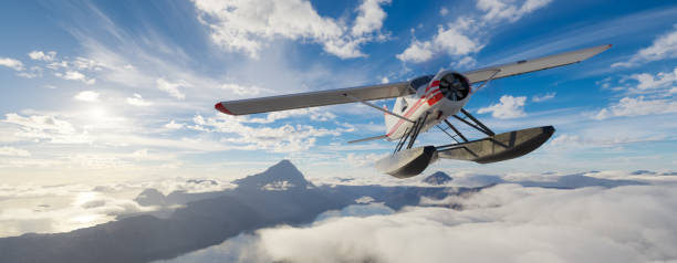 istock Airplane flying over mountains, lakes, and clouds. Sunny Da 2150999866