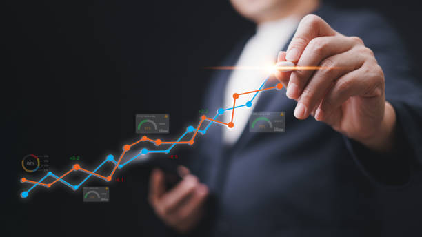 istock A businessman is drawing a graph on a screen with a phone in his hand. The graph shows a positive trend in concept of business analysis and information technology virtualize data. 2151003084
