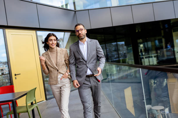 istock Cheerful Colleagues Exiting a Modern Office Building on a Bright Afternoon 2151003633