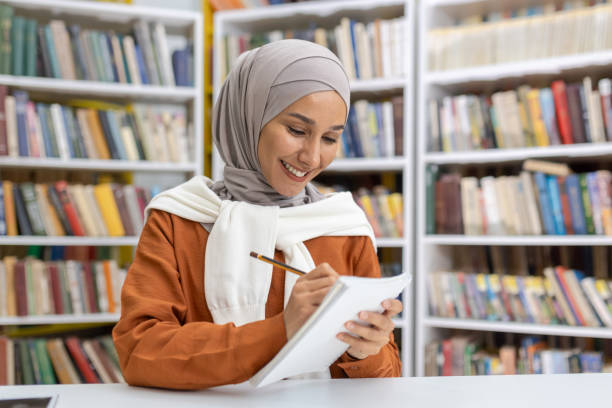 istock Muslim woman studying happily in a library setting 2151003668