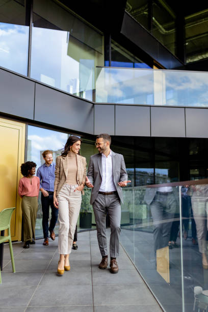 istock Cheerful Colleagues Exiting a Modern Office Building on a Bright Afternoon 2151003704