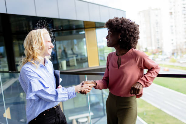 istock Two Professional Women Sharing a Joyful Conversation at a Modern Office Building 2151003719