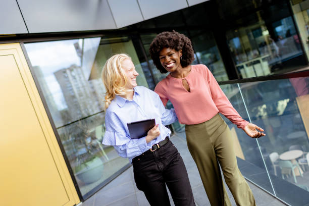 istock Two Professional Women Sharing a Joyful Conversation at a Modern Office Building 2151003725
