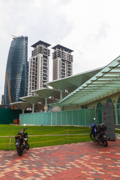Kuala Lumpur, Malaysia - November 25, 2019: Vertical street view with parked scooters and skyscrapers on the background