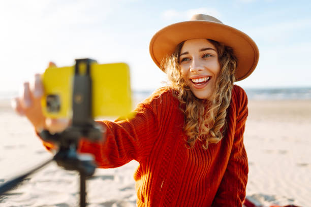 istock Stylish woman uses a smartphone on a tripod. 2151004058