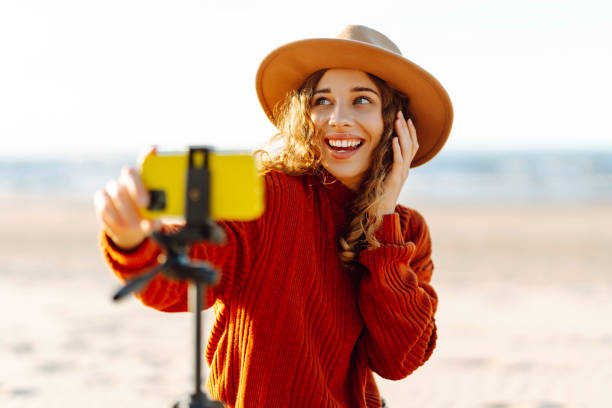istock Stylish woman uses a smartphone on a tripod. 2151004064