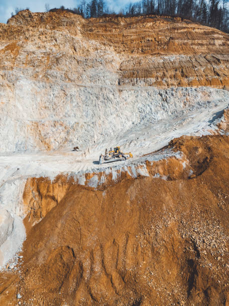 istock Excavator driving down a gravel road in open pit quarry - Vertical photo 2151004971