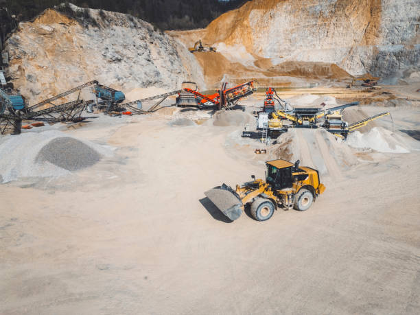 istock Working day in a quarry - Lots of heavy machinery operating on the grounds 2151005018