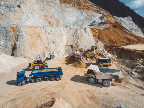 istock Working day in a quarry - Lots of heavy machinery operating on the grounds 2151005043