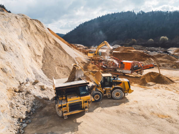 istock Working day in a quarry - Lots of heavy machinery operating on the grounds 2151005054
