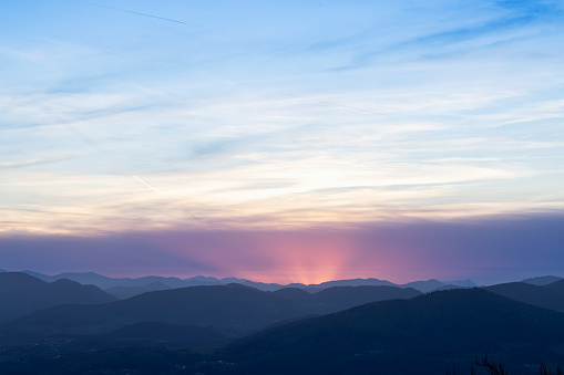 Tourism and travel concept image. Amazing silhouettes of mountains at a colorful sunset. View from Kulm Mountain, East Styria