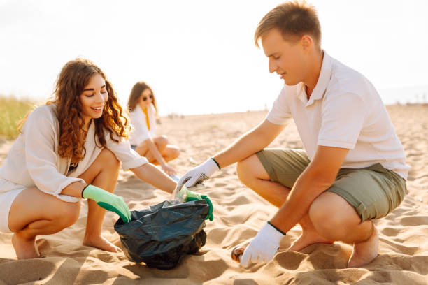 istock A volunteers collects plastic bottles on the ocean shore. 2151007765
