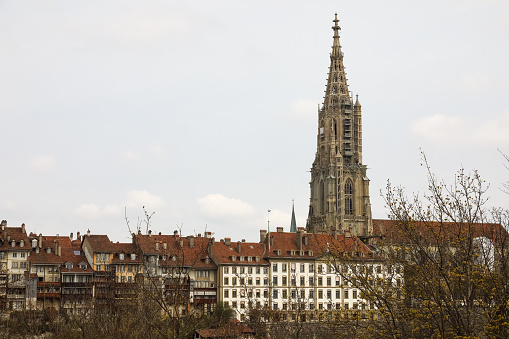Bern Switzerland - April 16, 2018: The Cathedral Tower dominates other historic townhouses in the Old Town.