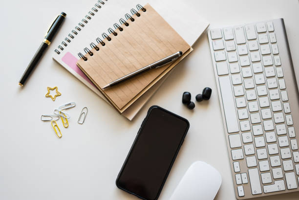 home office setup keyboard mouse smartphone notebook and pen are on the table horizontal still
