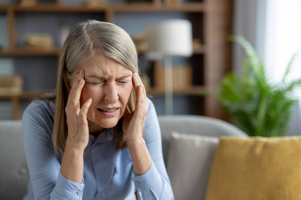 istock Senior woman feeling stressed with headache at home 2151012664