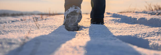 man walking in the snow at the sunset