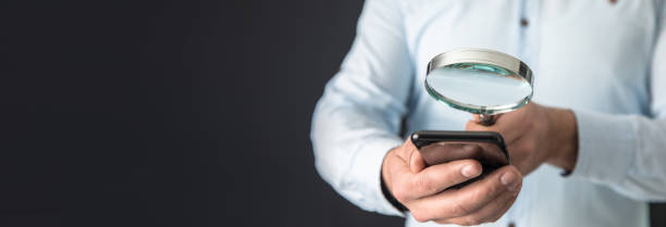 istock man holding magnifier and smart phone 2151016101